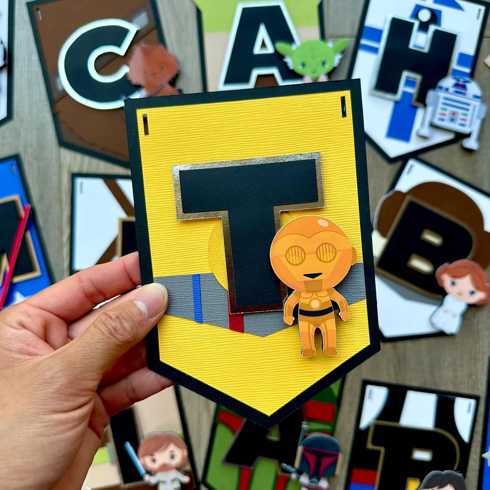 Close-up of the yellow T pennant with a golden droid character
